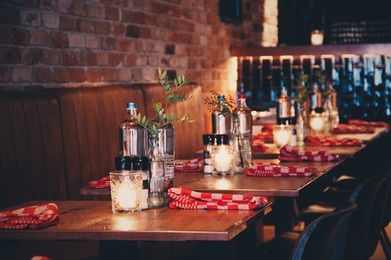 Tables set with red-checkered napkins at The Chicken Bar