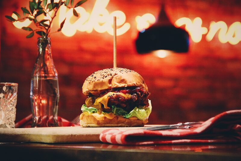 Chicken burger on the bar, the neon sign glowing behind